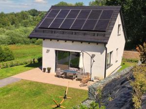 a tiny house with solar panels on the roof at Skośne Domki in Chmielno