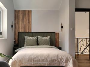 a bedroom with a large bed with a wooden headboard at Skośne Domki in Chmielno