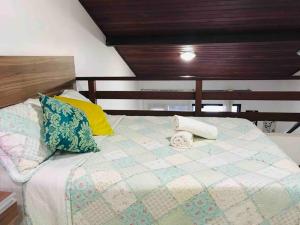 a bed with pillows on it in a room at Duplex no Centrinho de Pipa cozinha e 2 banheiros in Pipa