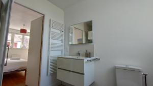 a white bathroom with a sink and a mirror at Charmante maison rénovée au bord de mer in Locmiquélic +18 photos