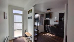 a room with a kitchen with a desk and a window at Charmante maison rénovée au bord de mer in Locmiquélic