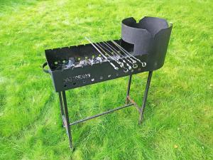 a black grill sitting on top of a field of grass at Auga Holiday Homes in Narva-Jõesuu +54 photos