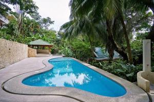 une piscine bleue à côté d'une maison dans l'établissement Tucán Studio Malpais, à Malpaís
