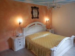 ein Schlafzimmer mit einem weißen Bett und zwei Nachttischen in der Unterkunft Schloßburg Reiserhof in Zell am Ziller