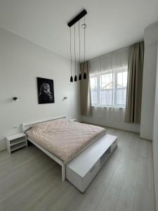 una camera da letto bianca con un letto e una finestra di Tamula Lake Loft apartment, Võru, Võru County a Võru