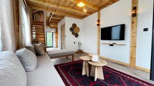 a living room with a couch and a tv on a wall at Hanging Garden Holiday Home - Riverside in Ardeşen