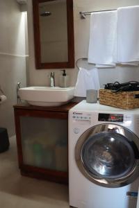a bathroom with a washing machine and a sink at Mine in Mytilini