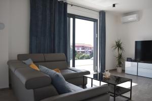 a living room with a couch and a table and a television at Villa M&M in Ližnjan