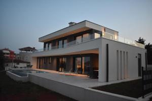 a house with a swimming pool in front of it at Villa M&M in Ližnjan