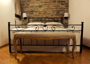a wrought iron bed in a room with a brick wall at ARIA DI CASA APARTMENT in Florence
