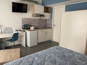 a room with a bed and a desk and a kitchen at Al Vicolo Comfort Room in SantʼAgata di Militello +21 photos