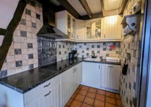 a kitchen with white cabinets and black counter tops at La Colline Stavelot in Stavelot