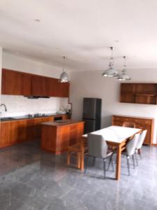 een keuken met een tafel, stoelen en een koelkast bij The Reserve in Harare