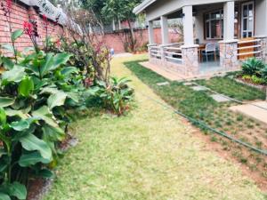 een huis met een tuin met een slang bij The Reserve in Harare