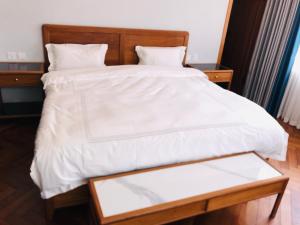 een bed met een wit dekbed erop bij The Reserve in Harare