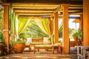 an outdoor patio with a pergola with a couch and chairs at Raha Wildlife Resort in Arusha