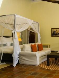 a living room with a bed and a white couch at Raha Wildlife Resort in Arusha +35 photos