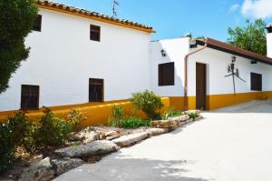 a white and yellow building with a driveway at Cortijo La Cañada in Zambra