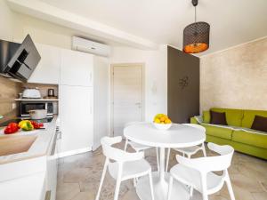 a kitchen and living room with a white table and chairs at Serenity with swimming pool and parking in Alassio in Alassio