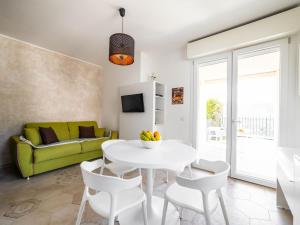 a living room with a white table and a green couch at Serenity with swimming pool and parking in Alassio in Alassio