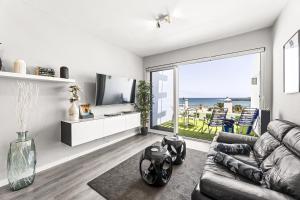a living room with a couch and a television at Holyhome cucharas beach in Costa Teguise