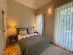 a bedroom with a bed and a large window at BlueCap by MyTrip Porto in Matosinhos