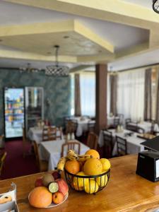 a bowl of fruit on a table in a restaurant at BLIM Restaurant Cazare Sound of Nature in Baia de Fier