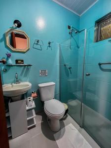 une salle de bain avec toilettes, douche et lavabo dans l'établissement Pousada Venezia, à Santo Antônio do Pinhal