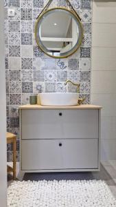 a bathroom with a sink and a mirror on the wall at Mala Lu Central Apartment in Varaždin