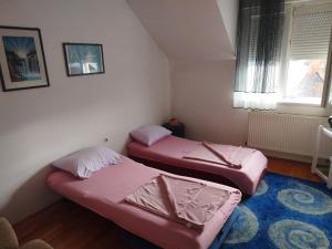 two beds in a small room with a window at Parovic in Nevesinje