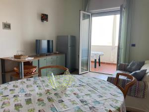 a living room with a table and a living room with a kitchen at Riva Sweet Home in Giovinazzo