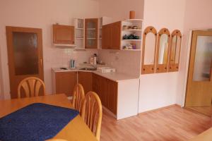 a kitchen with wooden cabinets and a table and chairs at S4 Červenohorské sedlo in Loučná nad Desnou