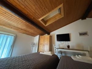 una camera da letto con un letto, una scrivania e una televisione di bed an breakfast Aurora a Trento