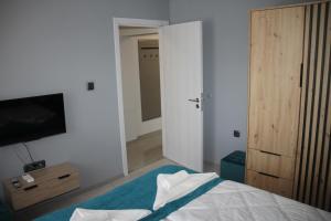 Un dormitorio con una cama y un televisor de pantalla plana. en First Line Apartment, en Balchik