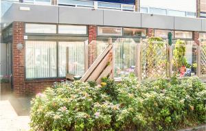 un jardín con una puerta de madera y algunas flores en Elfrank, en Bergen aan Zee