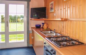 eine Küche mit einem Herd, einem Waschbecken und einem Fenster in der Unterkunft Beautiful Home In Ustronie Morskie in Ustronie Morskie
