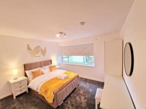 a bedroom with a large bed and a window at Charming 4 bedroom house in Nottingham -Entire House in Stapleford