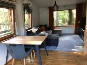 a living room with a table and a couch at Small resort Pini & SPA in Jūrmala