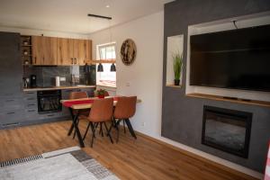 a kitchen with a table and chairs and a fireplace at Renatas Ferienwohnung Stanel in Sasbachwalden