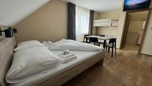 a bedroom with a bed with a table and a bathroom at Ubytování U Pupka in Vrbovec