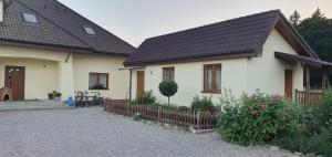 a white house with a fence in front of it at Pod Lasem in Przewłoka