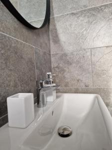 パランガにあるAmber Sea Apartment - 1の蛇口と鏡が付いたバスルームのシンク