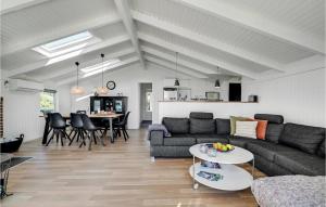 una sala de estar con un sofá y una mesa en Cozy Home In Hvide Sande With Sauna, en Bjerregård
