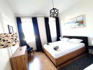 a bedroom with a bed and a desk and windows at Apartman Rijeka centar in Rijeka