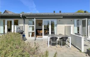 a house with a patio with a table and chairs at Awesome Apartment In Allinge in Allinge