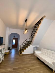 a living room with a white couch and stairs at Casa La Culle in Favareta
