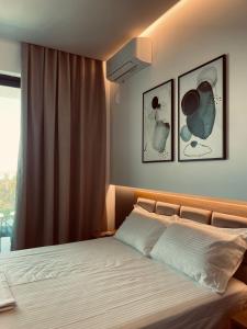 デルミにあるVilla27 Dhermiのベッドルーム1室(壁に2枚の写真が飾られたベッド1台付)