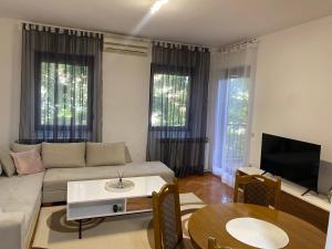 a living room with a couch and a table at Apartment Luka in Ljubuški +4 photos