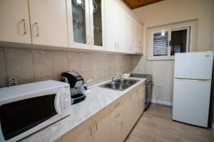 a kitchen with a sink and a white refrigerator at Home in Shkoder with Outdoor Pool in Shkodër