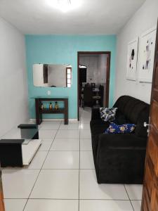 ein Wohnzimmer mit einer schwarzen Couch und einer blauen Wand in der Unterkunft Casa Festival de inverno Garanhuns in Garanhuns